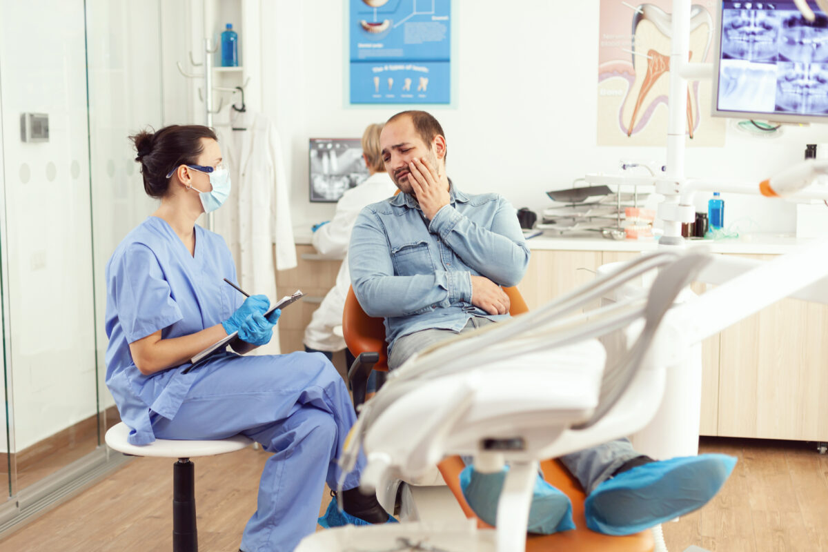medical-nurse-examining-patient-paing-writing-dental-problem-clipboard-while-sitting-dental-hospital-office-1200x800.jpg